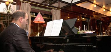 Orient Express - klavírista hrající při večeři