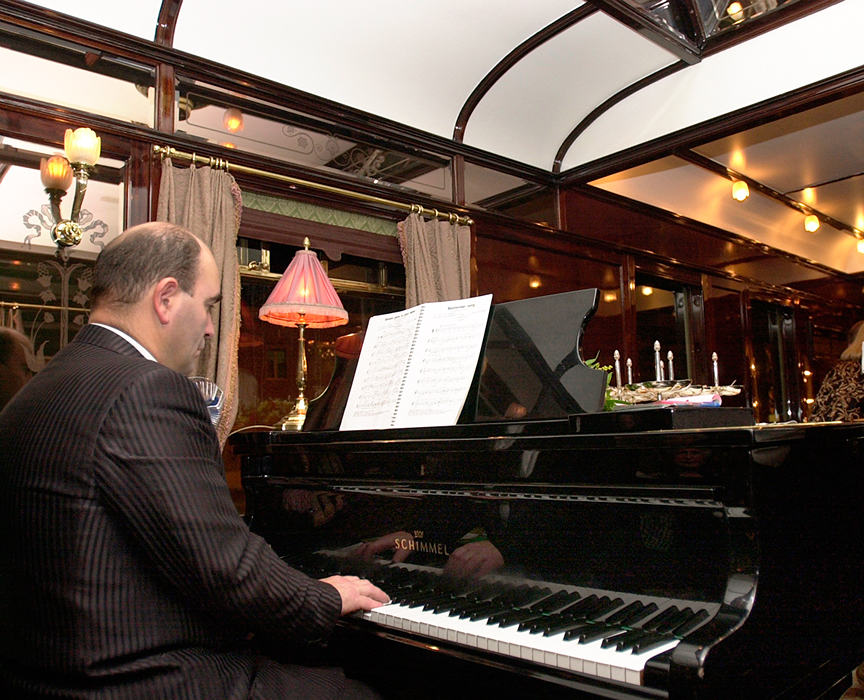 Orient Express - klavírista hrající při večeři