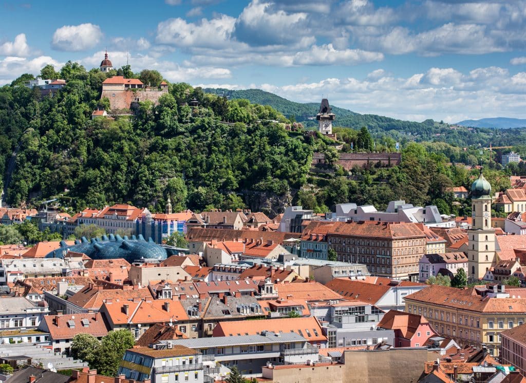 Celkový pohled na Štýrský Hradec s moderní budovou Domu umění a Zámecký vrch s Hodinovou věží