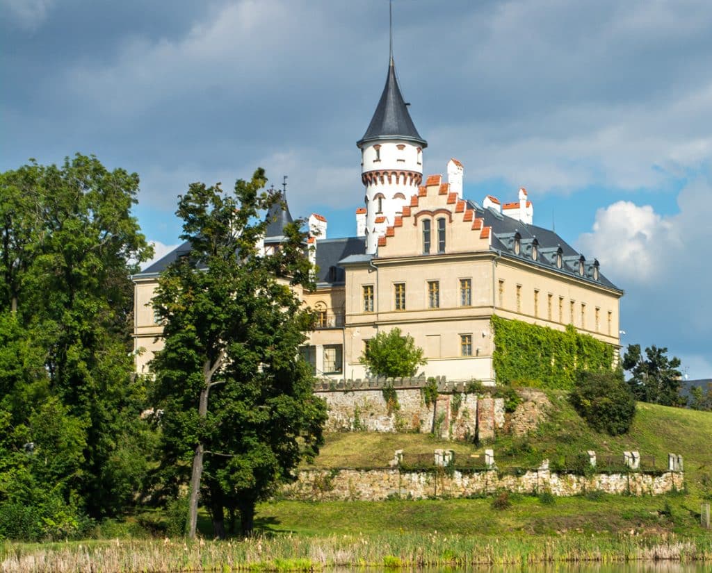 Pohled na zámek Raduň s hradební zdí a Zámeckým rybníkem