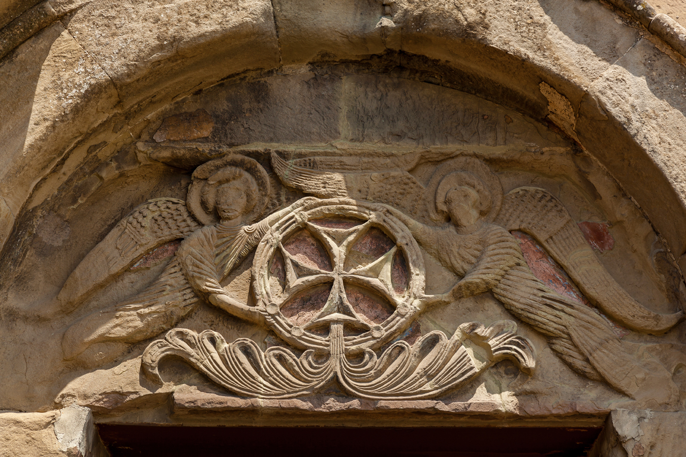Džvari - reliéf zobrazující kříž nesený dvěma anděly nad hlavním vchodem do kostela sv. Kříže