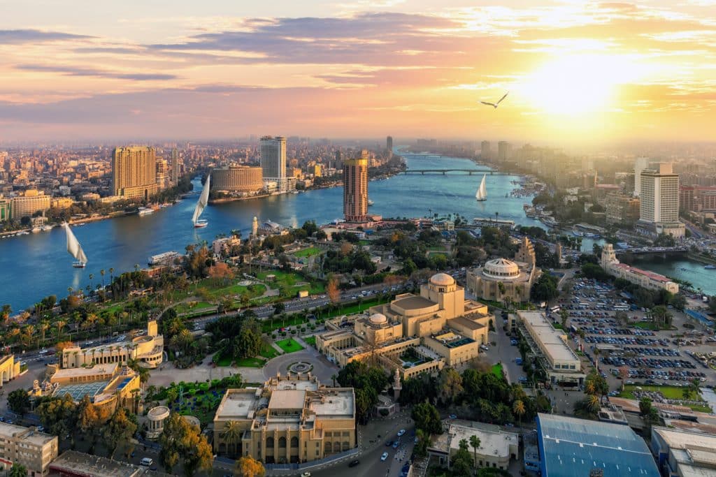 Káhira - Pohled na jižní část ostrova Gezira, kde stojí mj. káhirská Opera (velký žlutý komplex vpravo dole), a centrum Káhiry (vlevo vzadu). Druhý břeh Nilu (vpravo) patří již Gíze