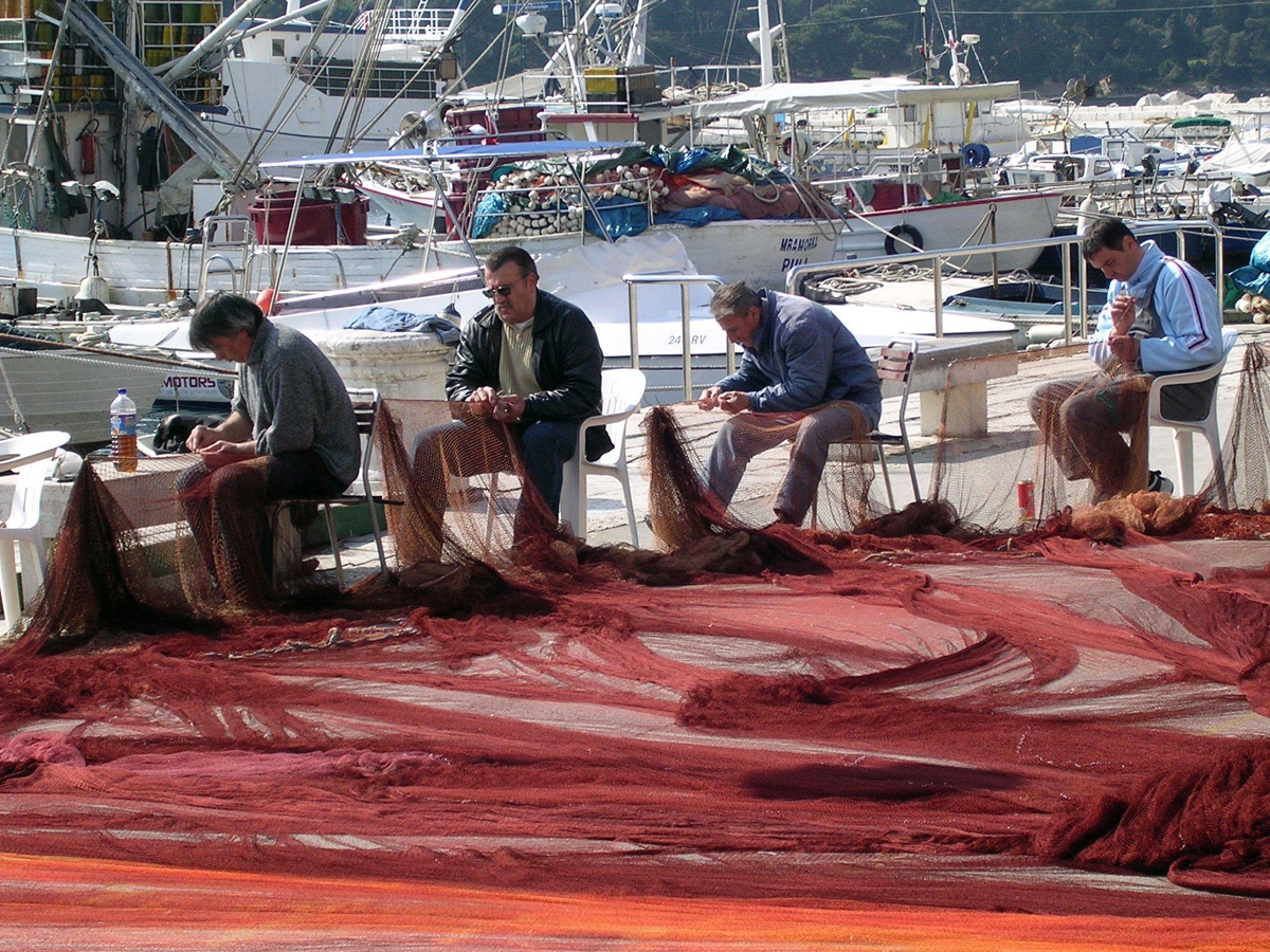 Rybáři spravující sítě v přístavu chorvatského města Rovinj