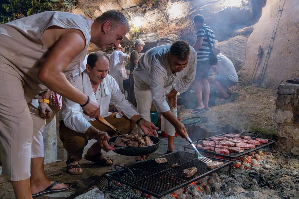 Grilování masa při tradičním středověkém festivalu ve městě Rab