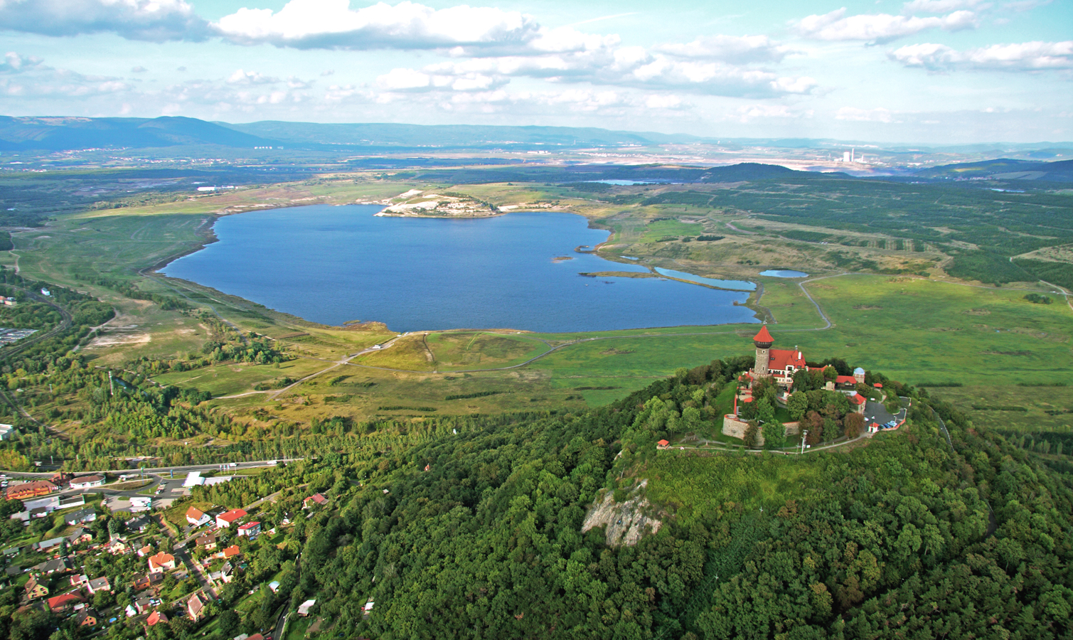 Pohled na jezero v době jeho napouštění, vpravo dole novogotický hrad Hněvín, který vznikl jako historizující rekonstrukce původního hradu, zbořeného po třicetileté válce